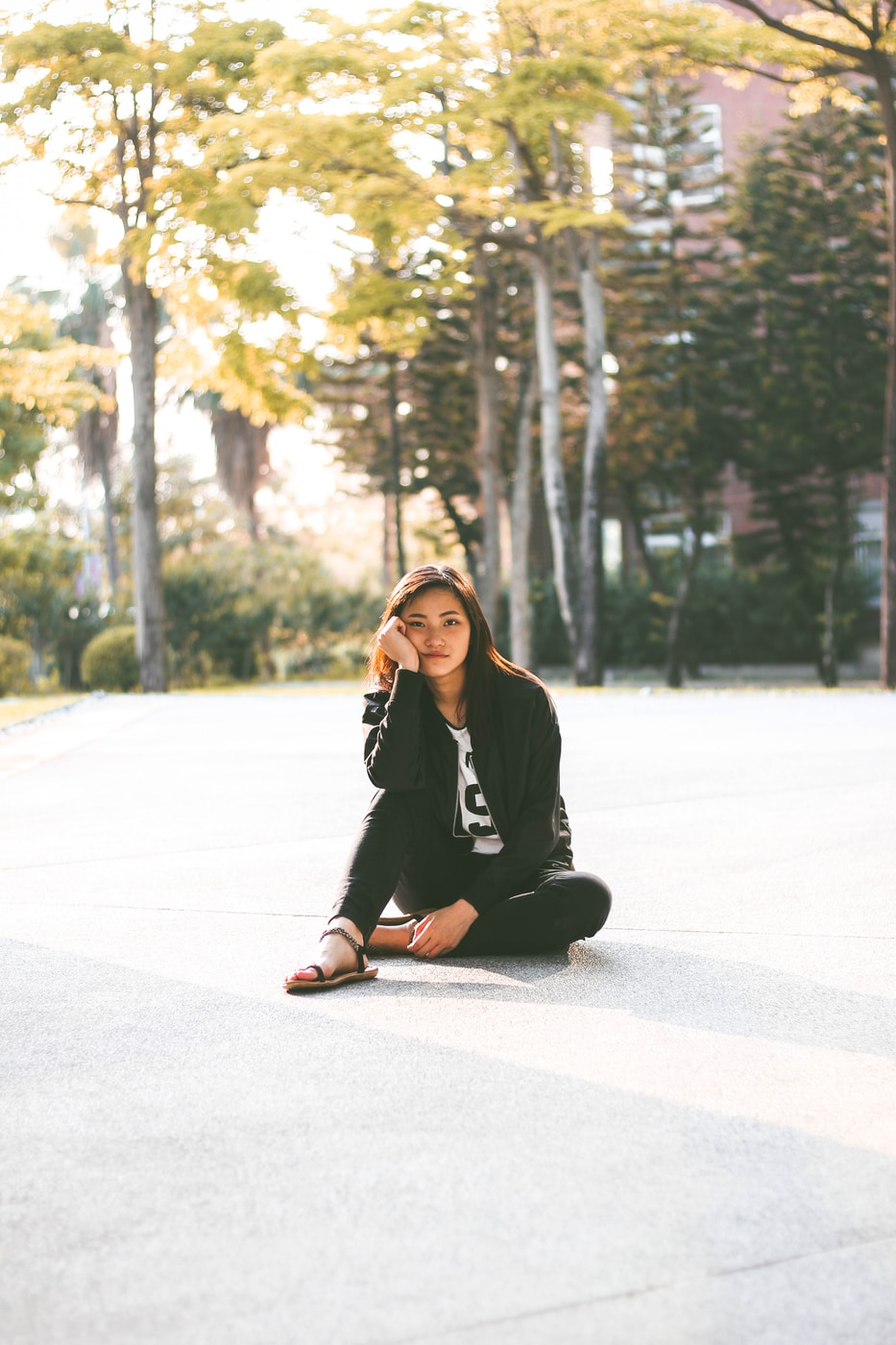 woman in black jacket while sitting on floor